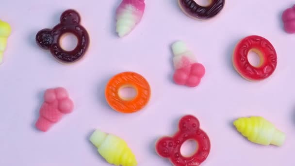 Fondo Varios Dulces Gelatina Osos Donuts Caramelos Sobre Fondo Rosa — Vídeo de stock