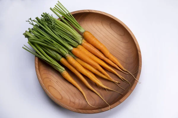 Beyaz arka planda ahşap bir kasede küçük havuçlar, üst manzara. Yüksek kalite fotoğraf