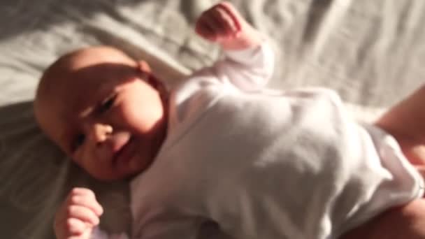 Een Baby Een Wit Bodysuit Rust Vredig Een Zacht Bed — Stockvideo