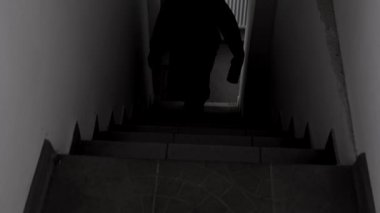 Bir adamın ya da bıçaklı bir manyağın ya da karanlıkta merdivenleri tırmanan bir baltalı adamın korkutucu amatör videosu. Korku, mistisizm, suç, katil. Yüksek kalite 4k görüntü