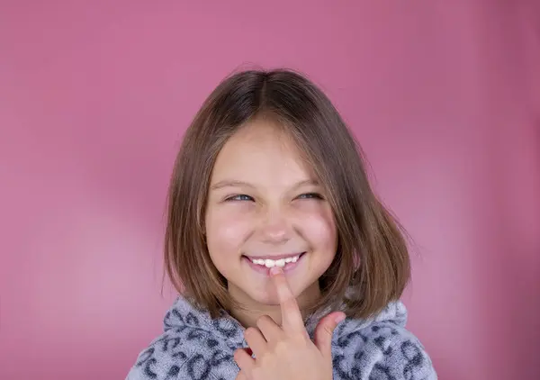 yaramaz kız, pembe arka planda sinsi bir yüzü olan güzel kız. Yüksek kalite fotoğraf