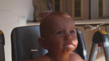 Çocuk pis yiyor, gülüyor ve gülümsüyor. Mutlu çocukluk hayali kavramı. Çocuk yulaf lapası suratında gülünç bir şekilde kirli, çocuk yemek yemeyi öğreniyor. Çocuk evde, sandalyede kirli yemek yiyor.