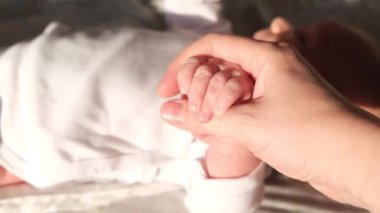 Kadınlar, anneler yeni doğmuş bir bebek ya da çocuğun elini tutarlar. Yüksek kalite 4k görüntü