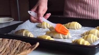 Kruvasan ya da simit pişirmek ya da evde kek pişirmek, çocuk mutfakta yemek pişirmek, yakın çekim yapmak, ev rahatlığı. Yüksek kalite 4k görüntü