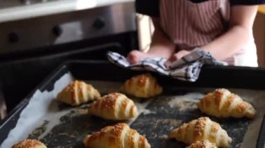 Kruvasan ya da simit pişirmek ya da evde kek pişirmek, çocuk mutfakta yemek pişirmek, yakın çekim yapmak, ev rahatlığı. Yüksek kalite 4k görüntü