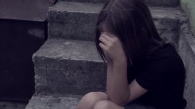 Üzgün, yalnız bir kız merdivenlerde yalnız oturuyor. Yalnızlık kavramı, zorbalık, kabadayıların ve gençlerin zihinsel sağlık sorunları. Yüksek kalite 4k görüntü