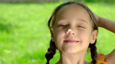 Doğanın arka planında örgülü saçları olan güzel bir kızın portresi. Yüksek kalite 4k görüntü