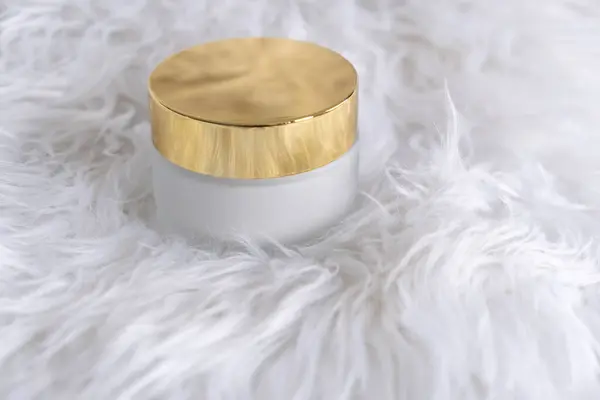 Beyaz arka planda altın kapağı olan nemlendirici krem için beyaz cam bir kavanoz. Ürün ambalajlama için bir model. Yüksek kalite fotoğraf