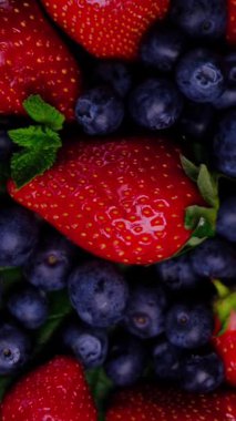 Kırmızı taze çilek ve yapraklı yaban mersini. Tatlı olgun böğürtlen. Böğürtlen arka planı. Sağlıklı vejetaryen yemeği. Yüksek kalite 4k görüntü