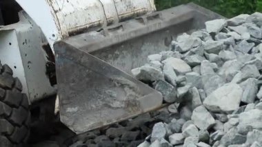 Gabion ya da inşaat işi için küçük yükleyici taşları getirip boşalttı. Yüksek kalite 4k görüntü