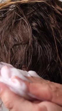 Saç bakım maskesi, saçlara elle sürme işleminin yakın çekimi. Yüksek kalite 4k görüntü