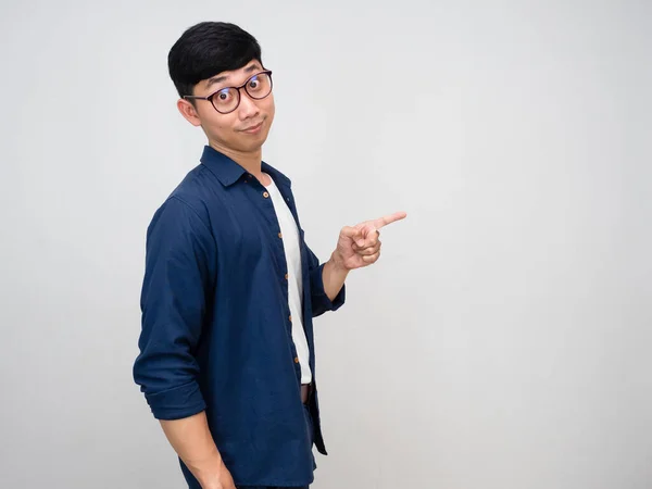 Positive asian man wear glasses turn around to point finger isolated