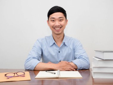 Pozitif Asyalı iş adamı çalışma masasında mutlu mesut oturuyor.