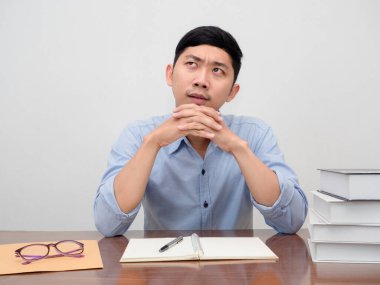 Pozitif erkek çalışan işyerinde oturuyor. Masa başı jestleri yapıyor.