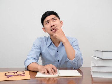 Asyalı işadamı çalışma masasında otururken kendini denenmiş ve sıkıcı hissediyor