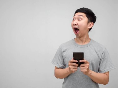 Genç Asyalı gri gömlekli adamın cep telefonu, izole edilmiş fotokopi odasına bakarken şok oluyor.