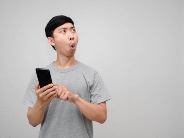 Gri gömlekli adam cep telefonu mimimiklerini tutarken heyecanlanıyor.