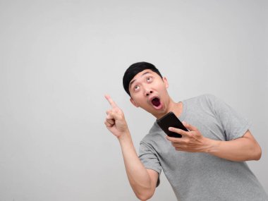 Gri gömlekli adam cep telefonu işaret parmağı tutarak ve izole edilmiş bir yere bakarak şok olmuş hissediyor.