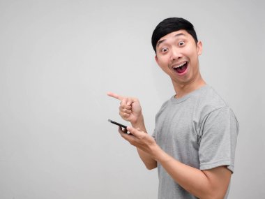 Gri gömlekli adam cep telefonu jest parmağını kenarda tutmaktan mutlu oluyor.