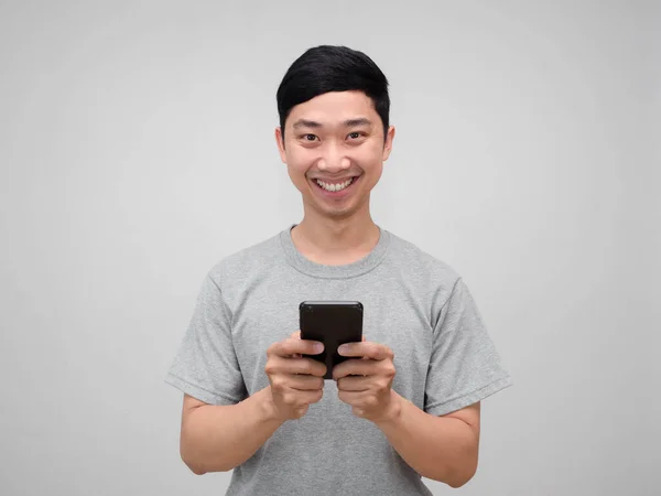 正アジア人男性グレーシャツホールド携帯電話幸せな笑顔隔離 — ストック写真