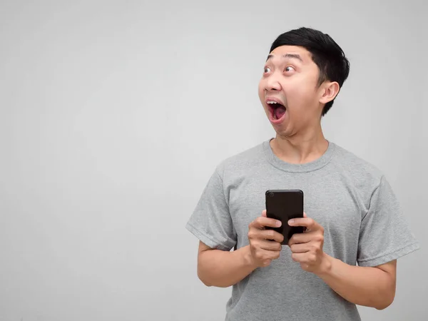 Genç Asyalı gri gömlekli adamın cep telefonu, izole edilmiş fotokopi odasına bakarken şok oluyor.