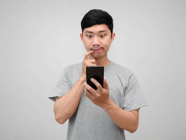 アジアの男灰色のシャツは空腹感を使用してスマートフォンを使用していくつかの食品を隔離 — ストック写真