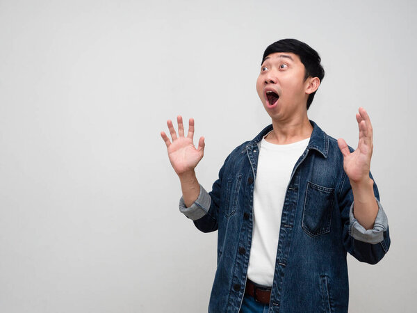 Asian man jeans shirt feels shocked looking at copy space isolated