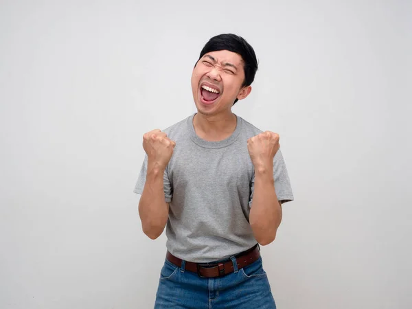 Pozitif Asyalı gri gömlekli adam yumruğunu göster. Başarılı olduğu için mutlu, zaferden memnun.