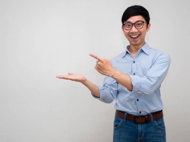 Portre yöneticisi mavi gömlekli adam gülümsüyor. Parmakla işaret ediyor.