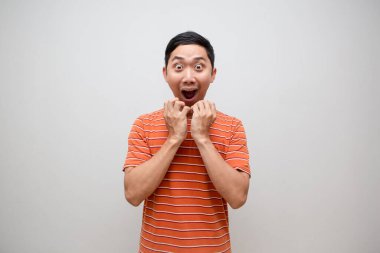 Asyalı turuncu gömlek heyecanlanmış, yüzü soyutlanmış.