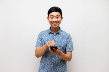 Pozitif Asyalı erkek mavi gömlek jest cep telefonuna izole edilmiş kullanım için basın