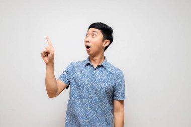 Pozitif neşeli adam mavi gömleği şaşırmış işaret parmağı izole