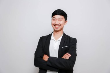 Asyalı siyah takım elbiseli, çapraz kollu düşünceli ve düşünceli.