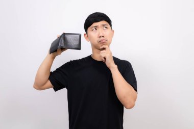 Asyalı siyah gömlekli adam cüzdanı boş tut. Üzücü bir jest yap.