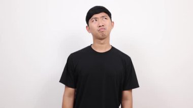 Asyalı adam siyah gömlekli, kafası karışmış ve sıkılmış hissediyor.