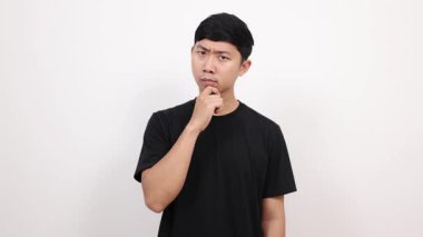 Asyalı siyah gömlekli adam düşünceli ve izole bir şekilde etrafa bakıyor.