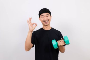 Pozitif Asyalı erkek siyah gömlek. Dambıl ile egzersiz yap.