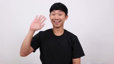 Asyalı adam ayakta duruyor ve el sallıyor. Hoşça kal de konsepti.