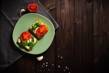 Avokado krem peynirli sağlıklı tostlar ve tabakta tam buğday ekmeği. Lezzetli atıştırmalıklar ve avokado sandviçleri. Yemek kompozisyonu, lezzetli İtalyan yemeği. Üst görünüm, alanı kopyala.