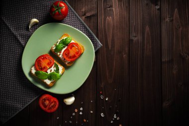 Avokado krem peynirli sağlıklı tostlar ve tabakta tam buğday ekmeği. Lezzetli atıştırmalıklar ve avokado sandviçleri. Yemek kompozisyonu, lezzetli İtalyan yemeği. Üst görünüm, alanı kopyala.