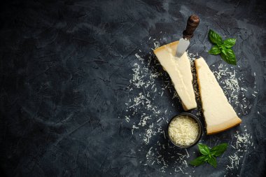 Koyu arkaplanda fesleğenli sert peynir, sert peynir, metin üst görünümü için yer.