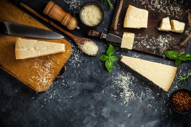 Siyah taşlı arka planda peynir bıçaklı sert peynirler. Parmesan peyniri. Üst Manzara. Metnin için boş yer.