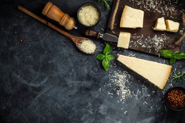 Siyah taşlı arka planda peynir bıçaklı sert peynirler. Parmesan peyniri. Üst Manzara. Metnin için boş yer.