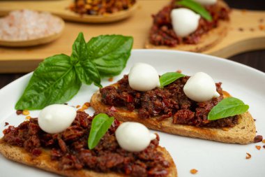 Küçük mozzarella peyniri, kuru domates ve fesleğenli Caprese tostları. Geleneksel Calabria yemekleri. Antipasti