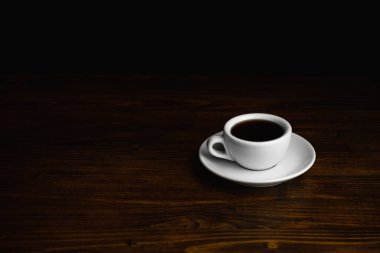 Tahta bir masada bir fincan kahve. Boşluğu kopyala