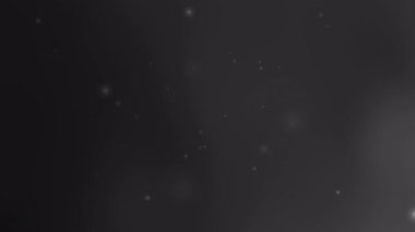 Uzay temalı tasarımlar ve büyülü arka planlar için uygun uzak yıldızları andıran soluk parlak beneklere sahip siyah gri arkaplan