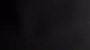 Yumuşak ışık parçacıkları ve pürüzsüz dalgalar ile koyu siyah soyut arkaplan Yeni Yıl kutlamaları veya lüks tasarım projeleri için ideal