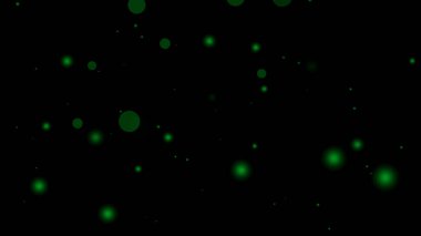 Siyah bir arkaplan üzerinde parlayan dairelerin yeşil parçacık örtüsü