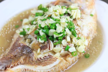 Baharatlı biber, sarımsak ve limon soslu Tilapia buğulaması, ahşap tepside sebze ve sebze, balık buharlı kireç. Tayland Çin yemeği.