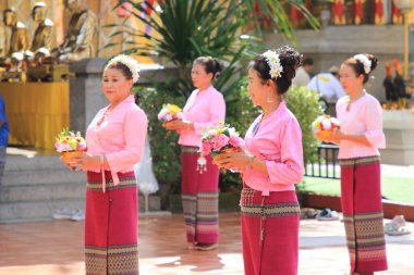 LAMPHUN -THAILAND: November 11, 2023:  Beautiful senior women perform an ancient Thai dance showing dancing in buddhist religious ceremony in TWat Phra That Haripunchai Woramahawihan. Thai nail dance with flower.
